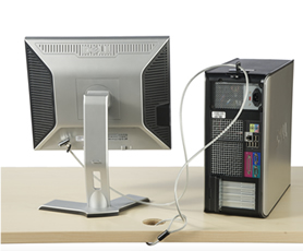 computer and monitor on top of a desk secured with a security cable looped through data hole in the desk